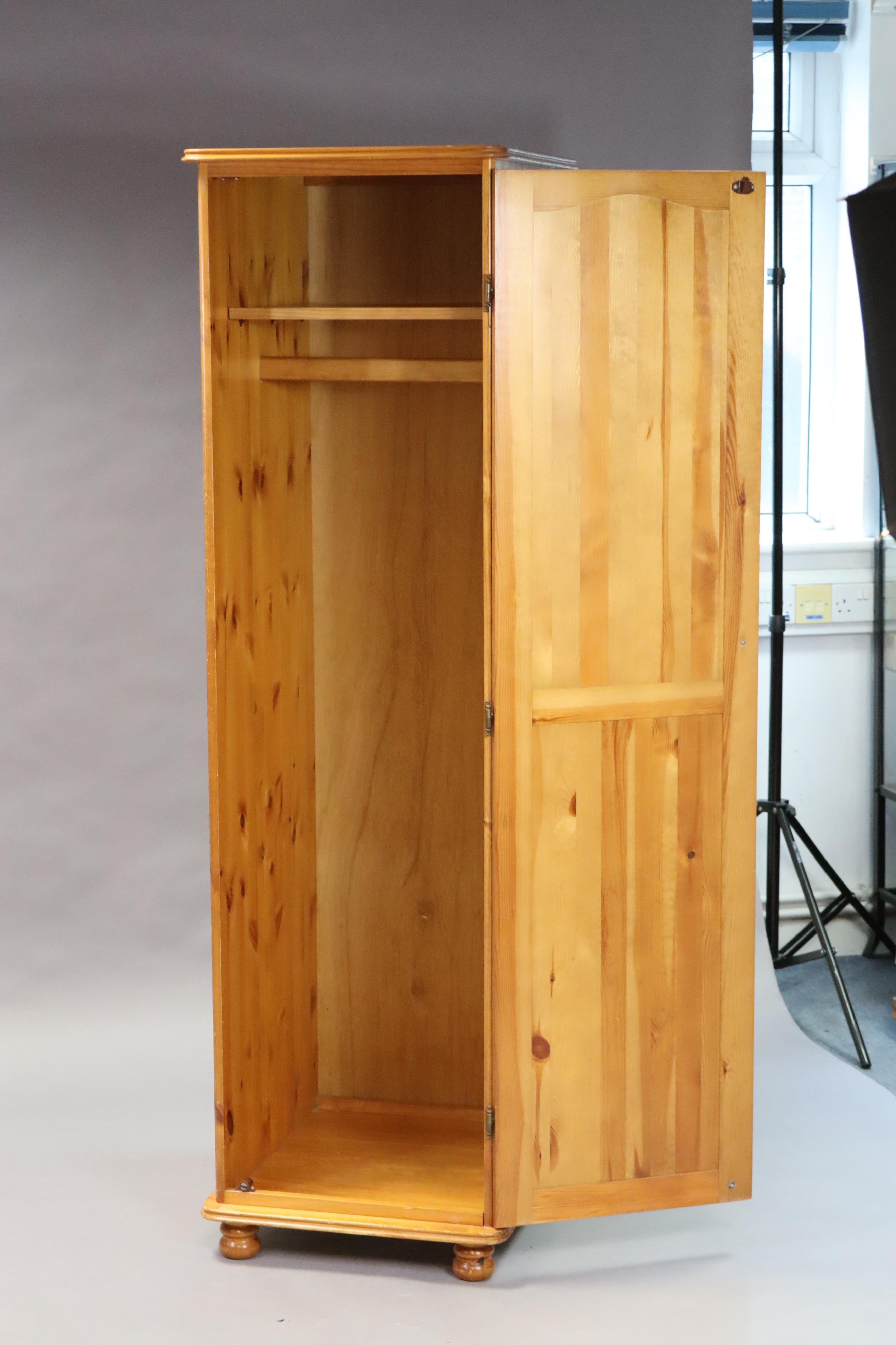 A pine narrow wardrobe enclosed by a fielded panel door, & on bun feet, 50cm wide x 175.5cm high x - Image 2 of 2
