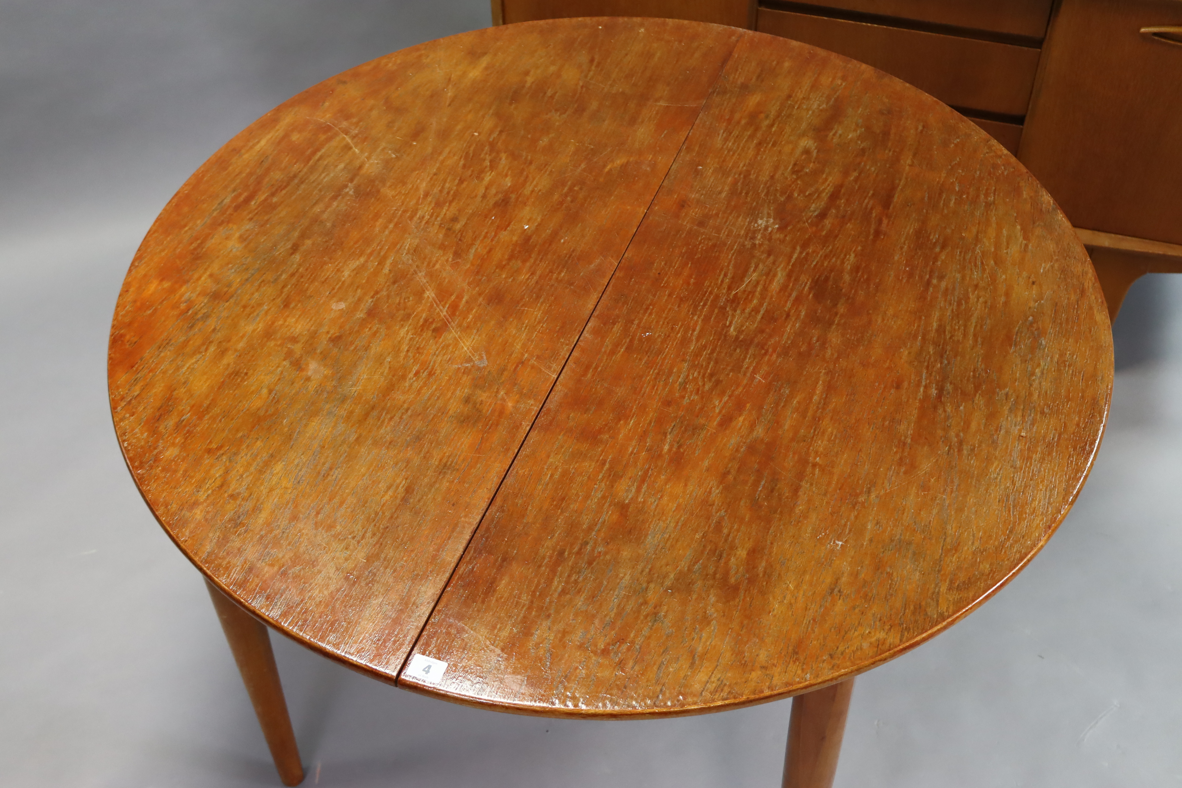 A mid-20th century teak dining room suite comprising of a circular extending table with a centre - Image 6 of 13