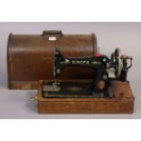 A Singer hand sewing machine with an oak carrying case.