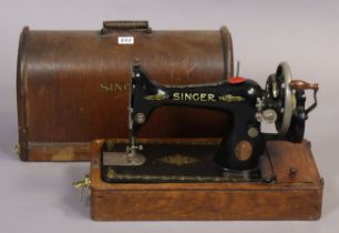 A Singer hand sewing machine with an oak carrying case.
