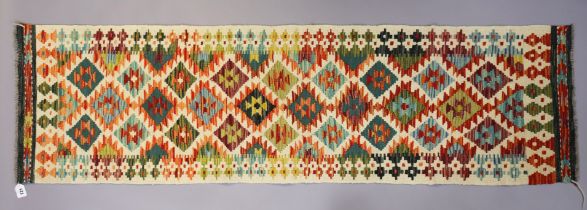 A Chobi Kilim runner of multi-coloured geometric design, 189cm x 54cm.