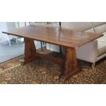 An oak refectory table with a rectangular top, & on shaped end supports joined by a shaped centre