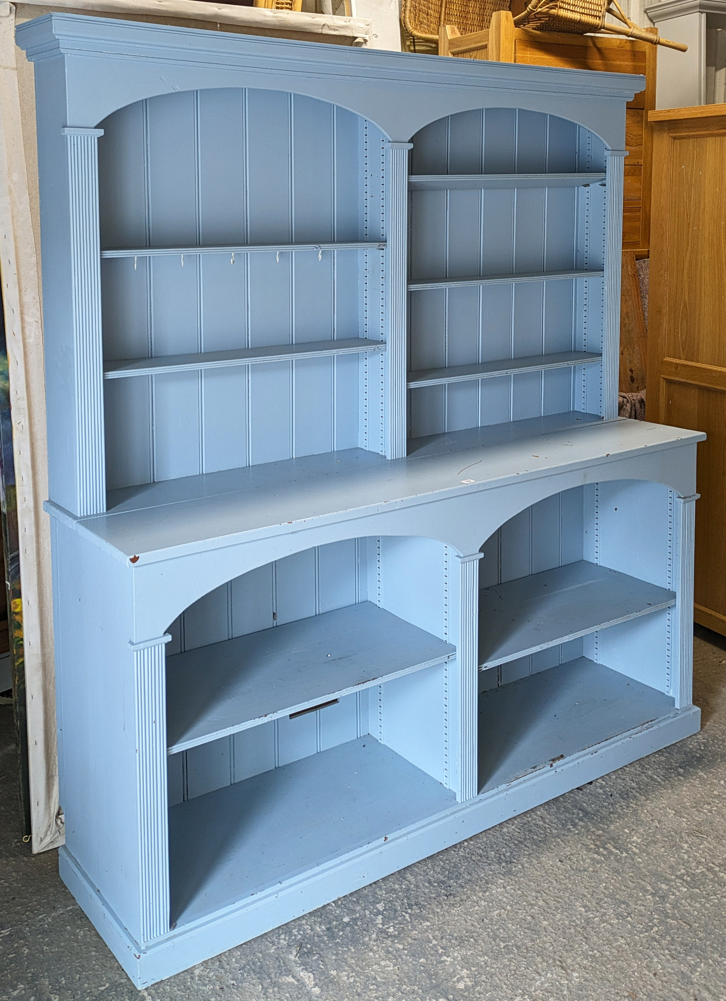 A pale blue painted pine dresser the upper part with five adjustable shelves & with a panelled back,