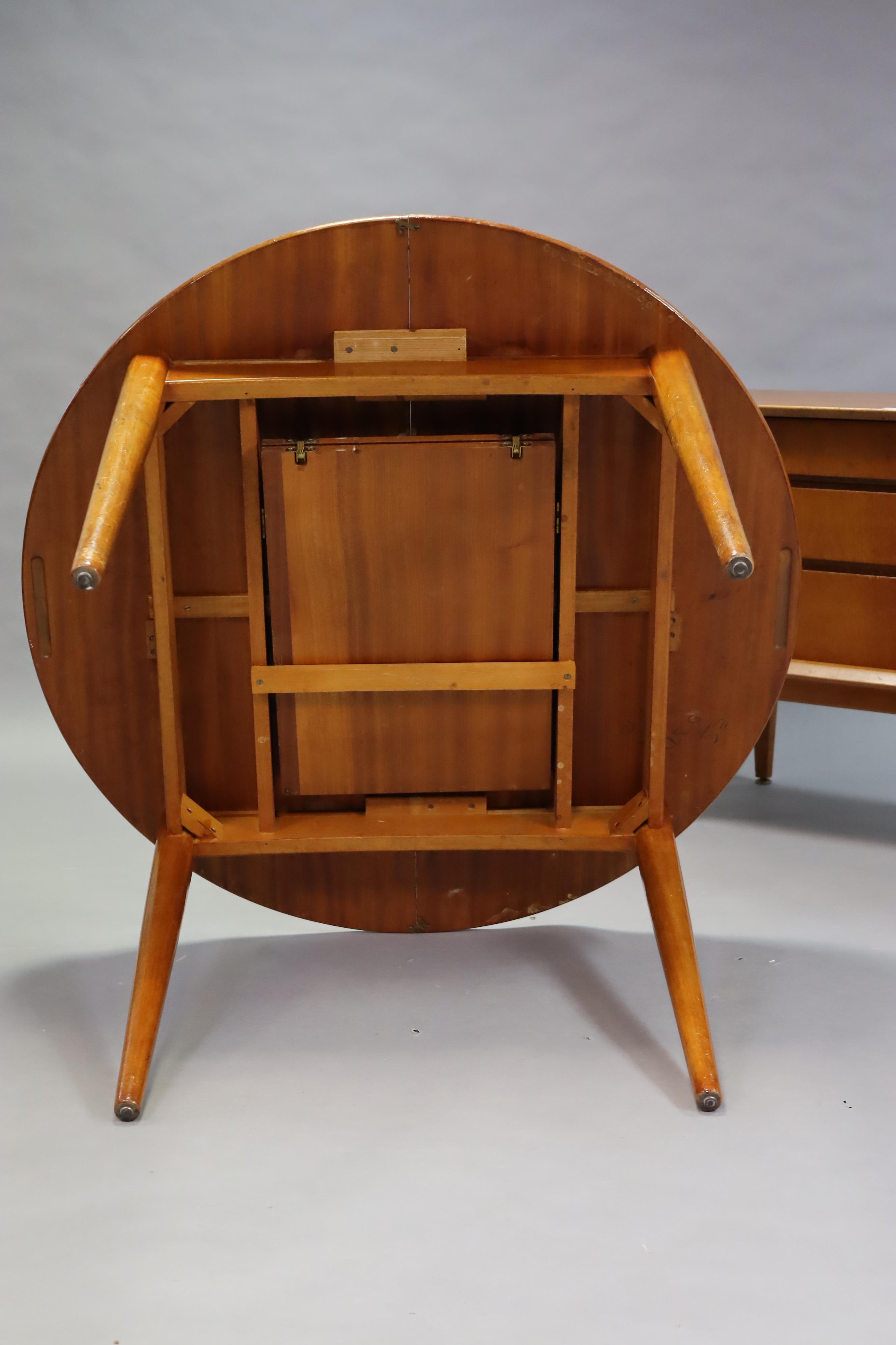 A mid-20th century teak dining room suite comprising of a circular extending table with a centre - Image 7 of 13