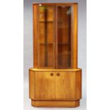 A mid-20th century teak tall standing corner cabinet by Turnidge fitted two plate-glass shelves