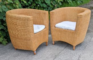 A pair of Heal’s tub-shaped wicker conservatory chairs.