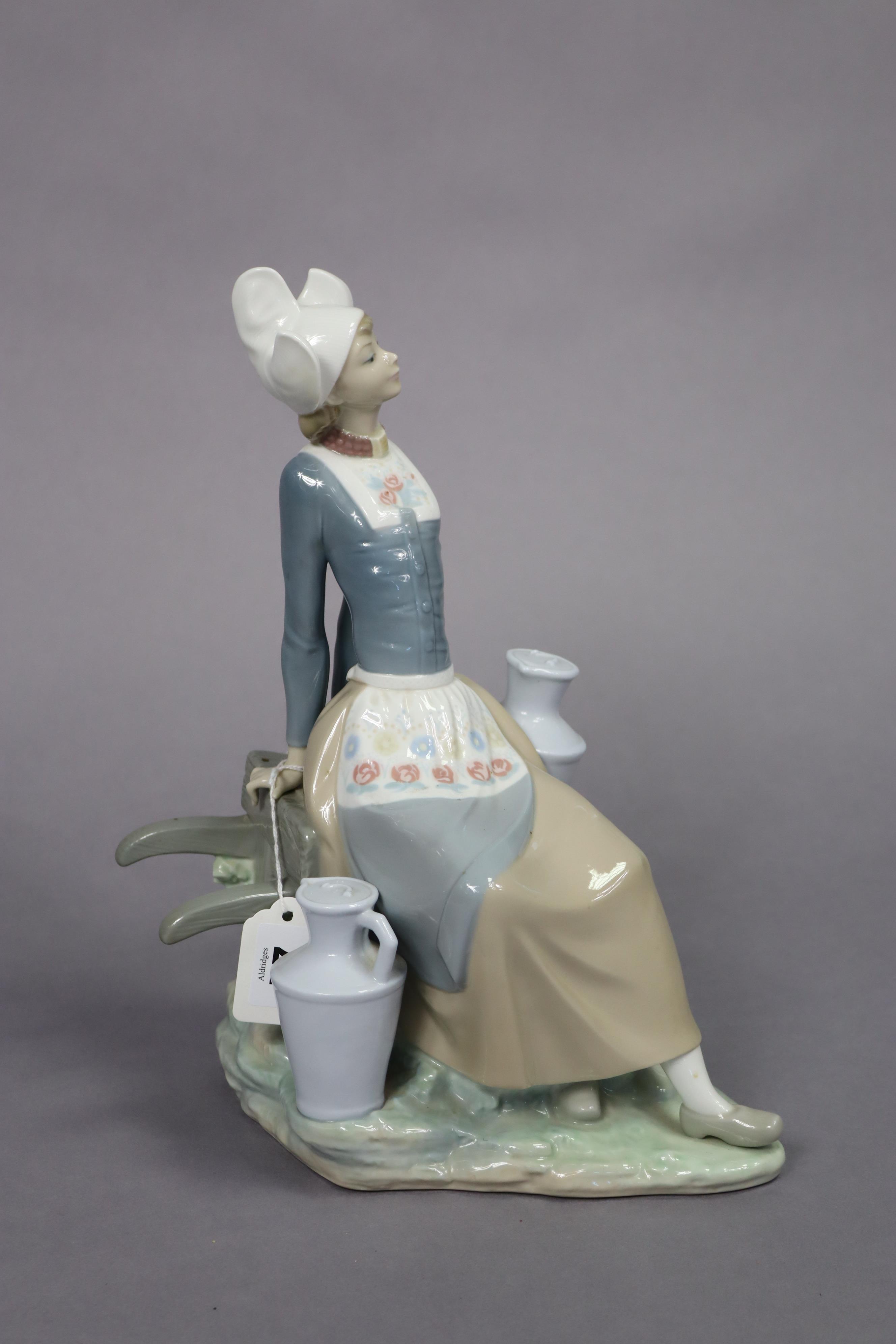 A Lladro porcelain figure of a milkmaid seated on a wheelbarrow, 32.5cm high. - Image 2 of 7