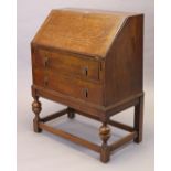 A 1930’s oak bureau having a fitted interior enclosed by a fall-front above two long graduated