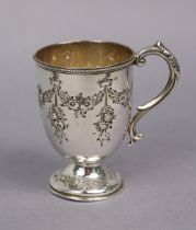 A Victorian silver christening mug of ovoid shape with embossed floral swags, on round pedestal