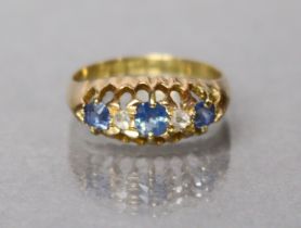 An 18ct. gold ring set three graduated pale sapphires, rose diamonds in between, Chester hallmarks