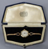 A 9ct. gold ladies’ wristwatch with octagonal case, silvered circular dial with Arabic numerals,