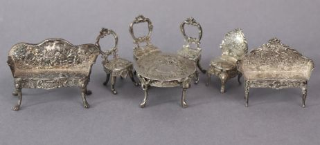 A collection of continental silver miniature furniture in the rococo style, comprising two sofas,