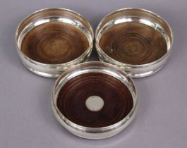 A pair of Elizabeth II silver wine coasters with rounded sides & inset turned wood bases, 13.2cm