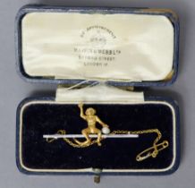 A 9ct. white & yellow gold bar brooch with seated monkey holding a seed pearl in its left hand, 4.