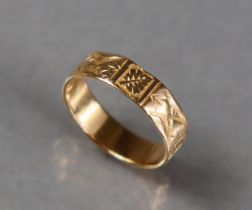 An 18ct. gold wedding band with engraved decoration; size: O/P, 3.5gm.