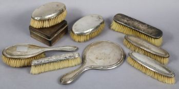 A George V silver rectangular cigarette box, Birmingham 1925; & seven silver-backed dressing table