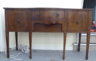 A 20thC reproduction of a Georgian string inlaid mahogany breakfront bow sideboard, raised on