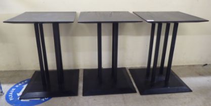 A set of three modern black stained oak lamp tables, raised on a cluster of square section supports