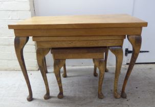 A nesting set of three mid 20thC beech and mahogany occasional tables, raised on slender legs and