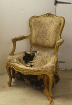 An early 20thC French inspired gilt framed open salon chair, raised on cabriole forelegs