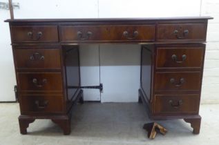 A mid 20thC mahogany nine drawer, twin pedestal desk, raised on bracket feet  30"h  48"w