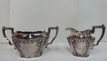 An early 20thC Art Nouveau Lee & Wigfull silver plated sugar basin and milk jug, decorated with