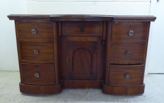 A late Victorian one-piece mahogany bow breakfront, six drawer kneehole desk, on a plinth  29"h