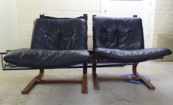 A pair of modern stained and laminated sprung beech framed chairs with black canvas and buttoned