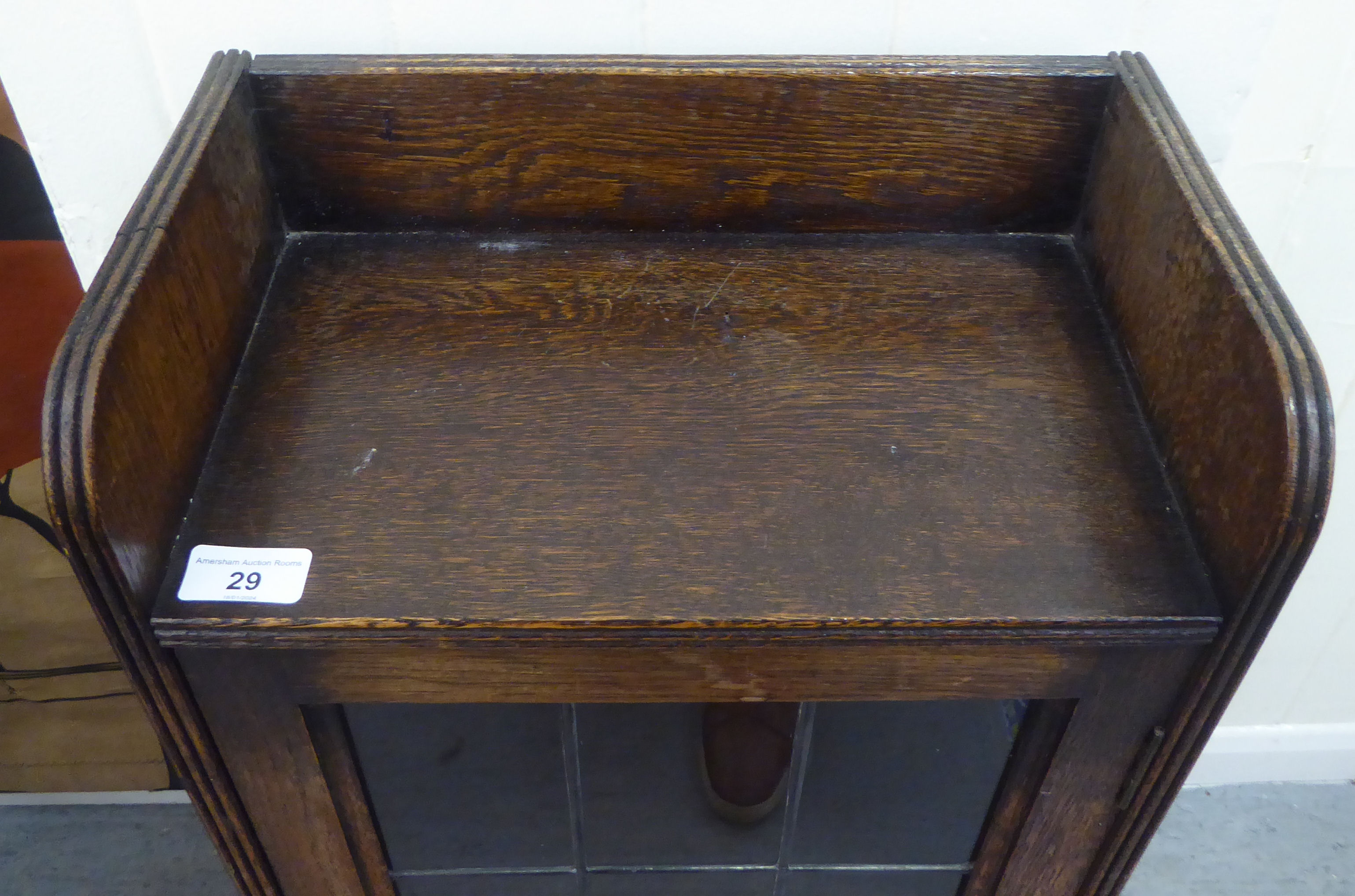 A 1920s oak bookcase, the lead framed and glazed door revealing three shelves, raised on bracket - Image 2 of 4