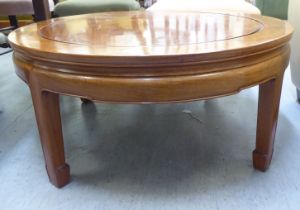 A modern Chinese style fruitwood coffee table, raised on chamfered legs  16"h  36"dia