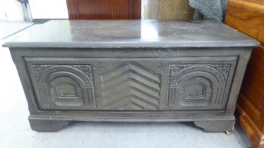 A modern, black stained mixed veneer chest, decorated with carved architectural designs,