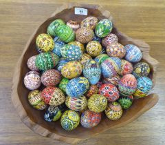 Painted chickens' eggs, decorated in floral, geometric and other designs; and a rough carved