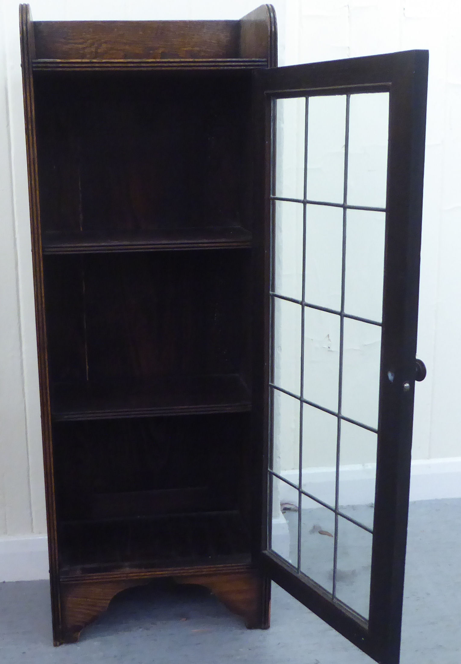A 1920s oak bookcase, the lead framed and glazed door revealing three shelves, raised on bracket - Image 3 of 4
