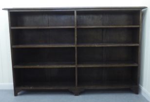 A modern oak dwarf bookcase, comprising two banks of four open shelves, raised on bracket feet  44"h