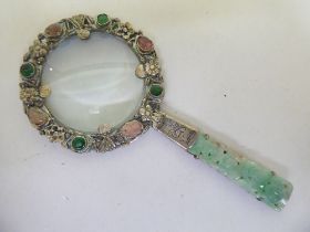 A Chinese white metal magnifying glass set with jade and cabochon cut gems