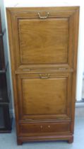 A mid 20thC Chinese fruitwood music cabinet with two fall front doors, raised on bracket feet  44"h