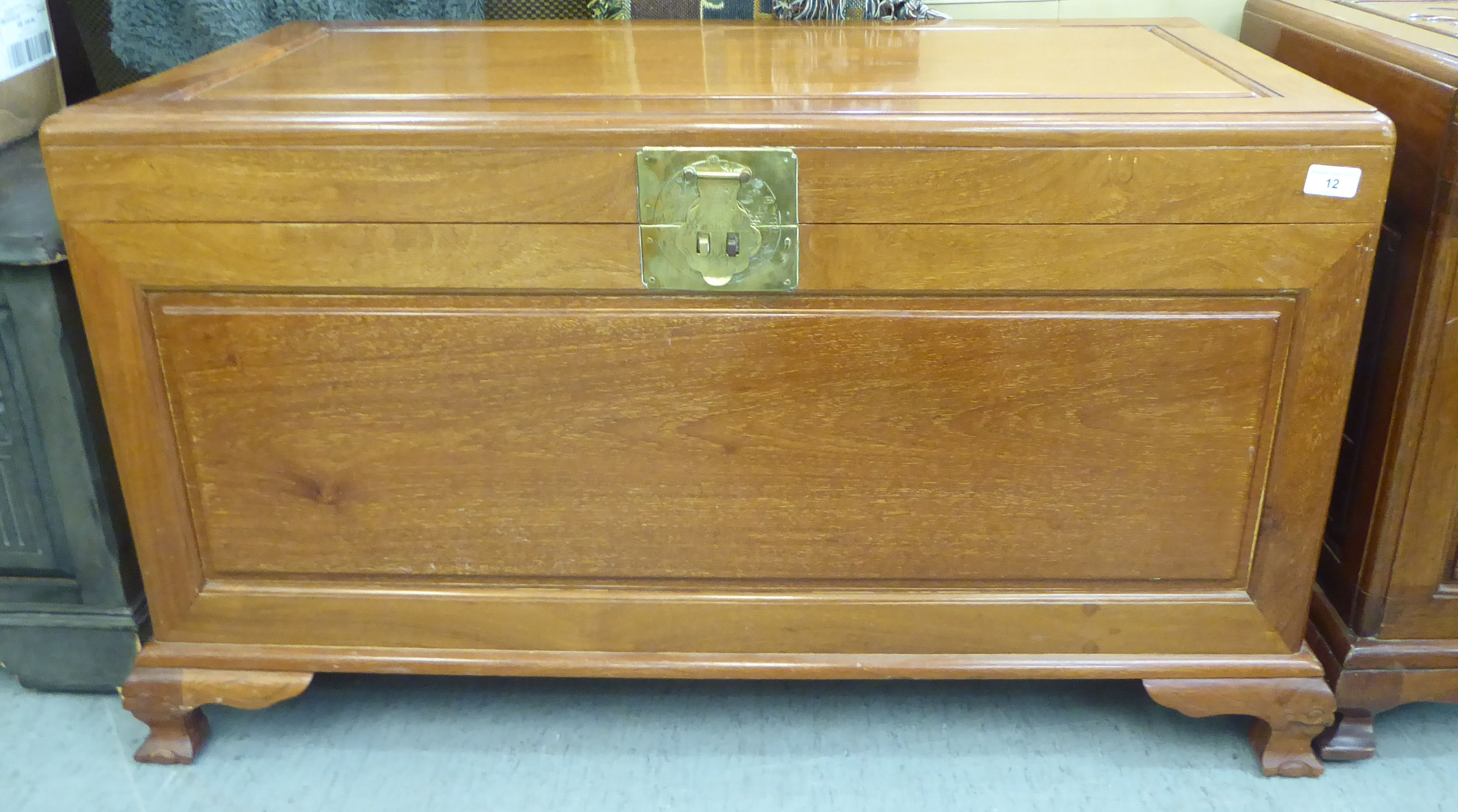 A mid 20thC Chinese fruitwood chest with a hinged lid, raised on cabriole legs  23"h  40"w
