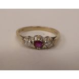 An 18ct white gold claw set, three stone, ruby and diamond ring