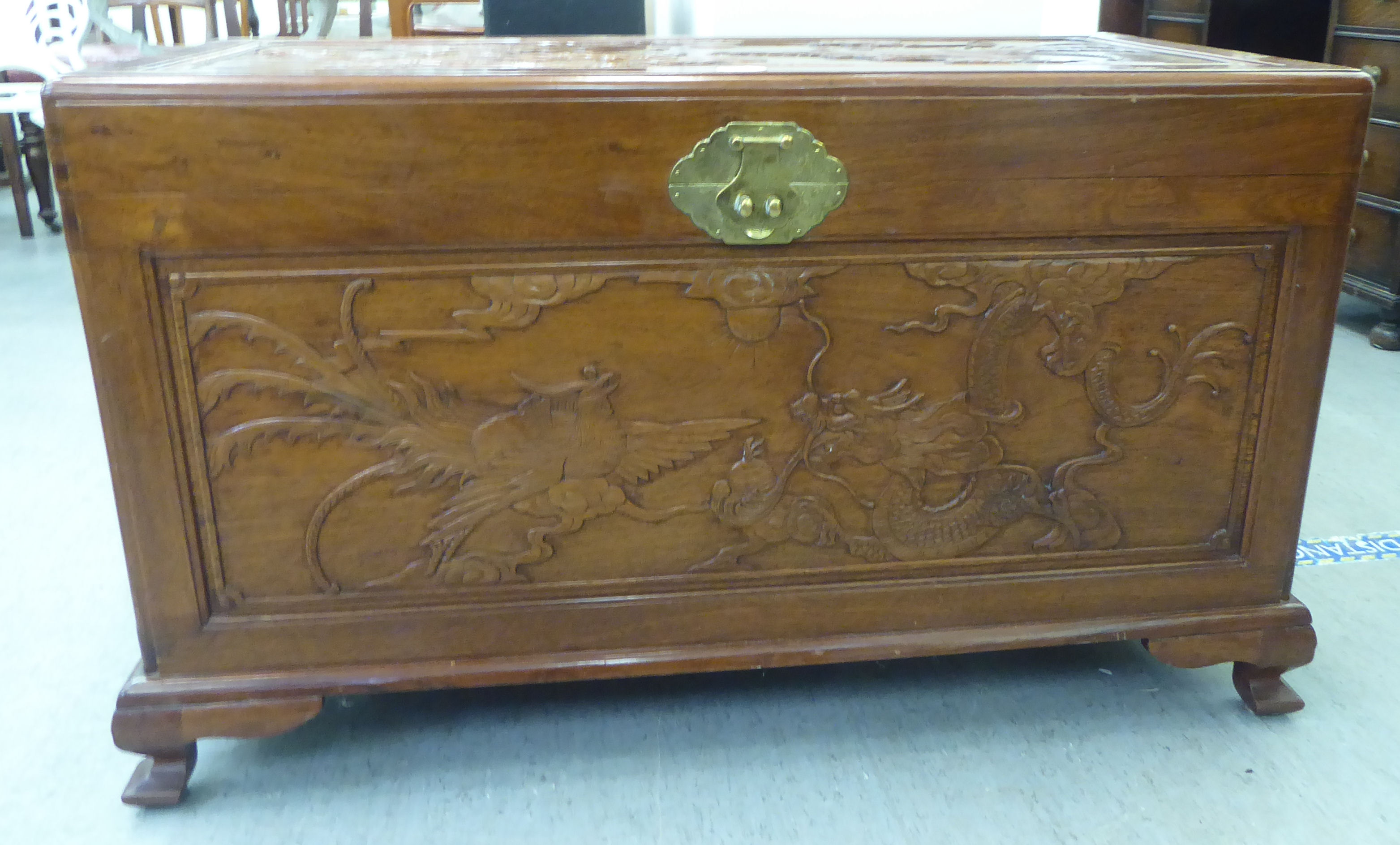 A mid 20thC Chinese fruitwood chest, allover carved with dragons, raised on bracket feet  24"h  41"w