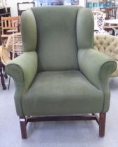 A modern Georgian style wingback arm chair, upholstered in green fabric, raised on oak, block legs