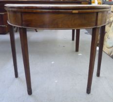 A Regency mahogany demi-lune card table with a foldover top, raised on square, tapered legs  28"h