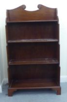 A modern Regency style mahogany four tier waterfall front bookcase, raised on bracket feet  41"h