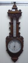 An early 20thC oak cased aneroid barometer by G.Blackhurst & Son with a painted enamel dial  35"h