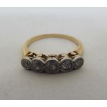 A yellow metal ring, set with a row of diamonds