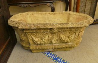 A composition stone garden trough with mask motifs  12"h  32"w
