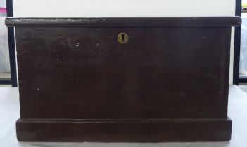 A mid 20thC brown painted pine box with a lockable, hinged lid and opposing recessed brass