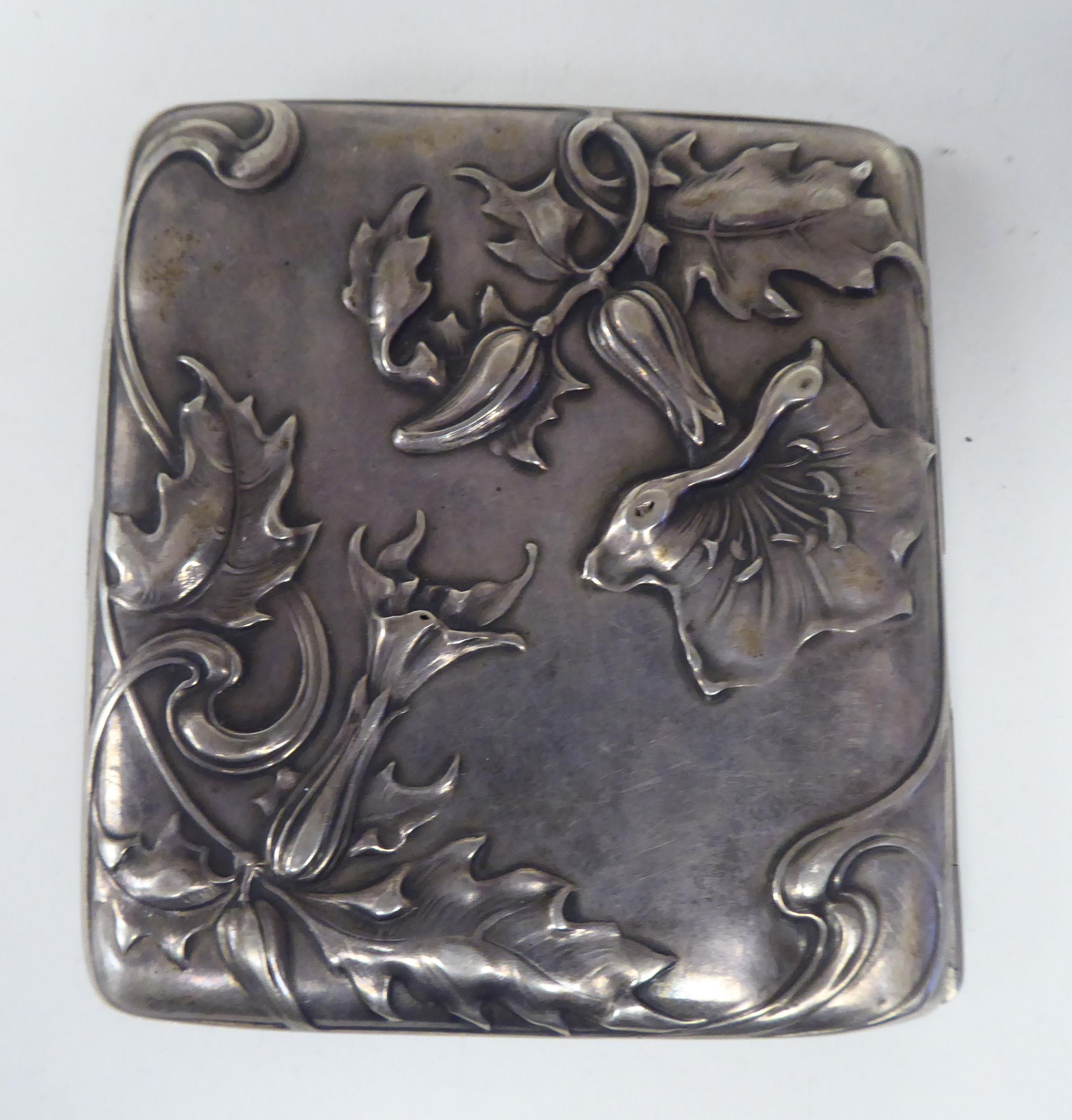 An Art Nouveau silver coloured metal, folding cigarette case, on a button clasp, embossed and chased - Image 3 of 3