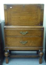 A 1930s oak bureau with a fall front and two drawers, raised on bulbous, turned legs  43"h  26"w