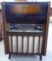 A vintage Aristrona freestanding valve radiogram, in a wood veneered case  34"h  23"w