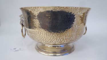 A George V silver punch bowl with spot-hammered finish, a flared rim and opposing twin lion masks